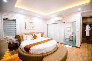 Hà ÐôngLam Anh Hotel Him Lam Vạn Phúc Hà Đông的一间卧室配有一张大床和一把椅子