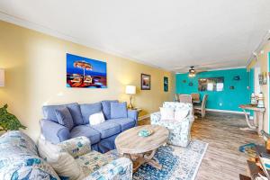 沃尔顿堡滩Island Echoes 5L的客厅配有蓝色的沙发和椅子