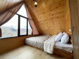 卡兹贝吉Cozy Home Kazbegi的一张位于带大窗户的房间内的床铺