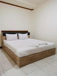 芭东海滩Global Hotel Beach View的一间卧室配有一张带白色床单的大床