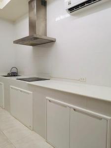 芭东海滩Global Hotel Beach View的厨房配有白色橱柜和炉灶。