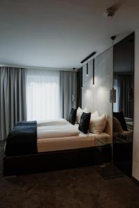 弗拉绍The Place Boutique & Design Hotel Flachau的一间卧室设有一张大床和一个窗户。