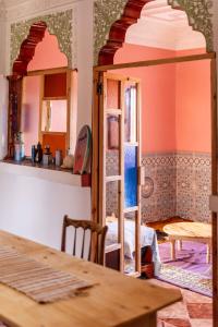 西迪考乌奇Ayour Hostel的一间设有一张桌子的房间和一间带镜子的房间