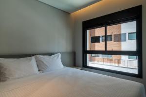 圣保罗EZ Moema Hotel的一间卧室设有一张床和一个窗口