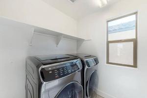 凤凰城The Spotless 2 Story的洗衣房配有洗衣机和烘干机以及窗户。