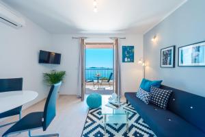 米利尼Apartments Villa Made 4U的客厅配有蓝色的沙发和桌子
