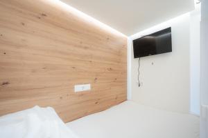 维也纳Robin Wood Apartment的一间设有床铺和墙上电视的房间