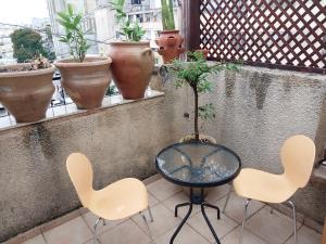 Giv‘at Shemuʼelשירת דבורה בבני ברק的阳台配有桌椅,种植了盆栽植物