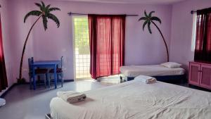 拉斯加勒拉斯Il Triangolo Hostel的一间卧室设有两张床,两棵棕榈树