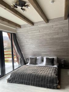彼得罗沙尼Valea Mosului - Charme A Frame的一间卧室设有一张大床和一个大窗户