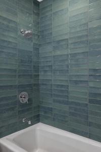 盐湖城摩纳哥盐湖城金普顿酒店的浴室设有绿色瓷砖墙壁和浴缸