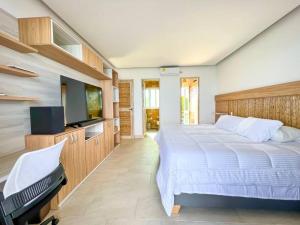 托卢Suite, Eco Hotel Laguna Beach的一间卧室配有一张大床和一台平面电视