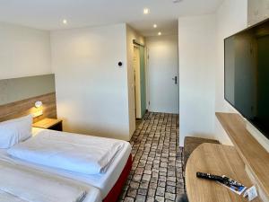 吕德斯海姆科兰切酒店的配有一张床和一台平面电视的酒店客房