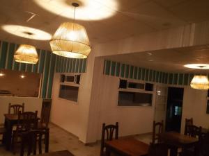 米娜克拉韦罗Hosteria Rukalaf的用餐室配有桌椅和吊灯。