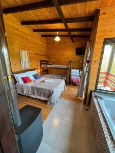 乌鲁比西Chalés incríveis com banheira de hidromassagem e vista encantadora的木制客房内的一间卧室,配有一张床