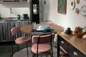 贝洛奥里藏特Casinha do Prado, conforto vintage, ar condicionado的厨房配有桌椅
