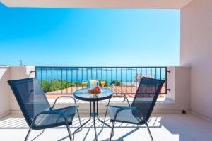米利尼Apartments Villa Made 4U的海景阳台上的桌椅