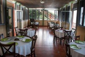 弗洛勒斯Ribiera del Lago Peten Itza的餐厅设有白色的桌椅和窗户。