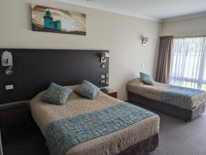 沃加沃加澳洲家园汽车旅馆 的酒店客房设有两张床和窗户。