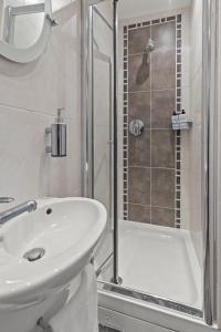 伊灵Cosy Flat In London的白色的浴室设有水槽和淋浴。