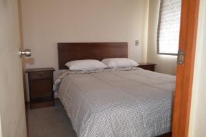 特木科Katri apart的一间卧室配有一张床和一个木制床头板