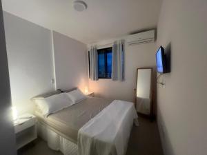马塞约Novíssimo, 500m Praia, Garagem, Vista - Luzes do Arrebol的一间白色卧室,配有床和电视