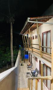 圣米格尔-杜戈斯托苏Gostoso Maresia Flats的阳台,带椅子和棕榈树的建筑