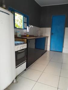 马卡埃Cantinho do sossego的厨房配有炉灶和蓝色的门