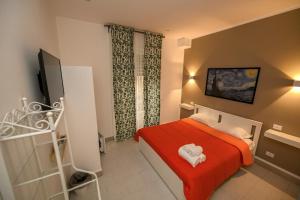 萨莱诺Living Salerno B&b的一间小卧室,配有红色的床和2条毛巾