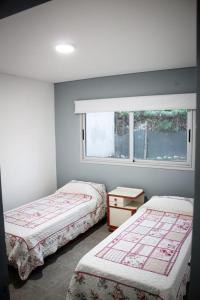 卢汉德库约un sueño para viajar的一间卧室设有两张床和窗户。