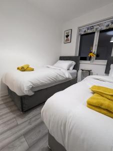 BentleyFreshen-up stays Doncaster的一间卧室配有两张带黄毛巾的床。