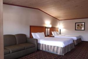里兹波特Anchor Bay Inn By OYO Reedsport的酒店客房,设有两张床和一张沙发