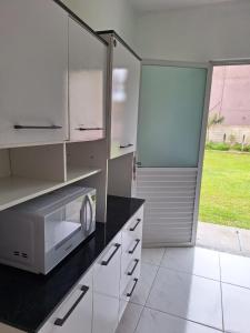 弗洛里亚诺波利斯Residencial Caramujo的厨房配有白色橱柜和微波炉