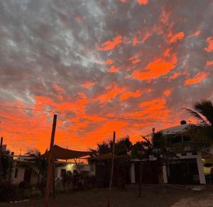 El SargentoSelenes Hostel的落日时,满屋和棕榈树的天空