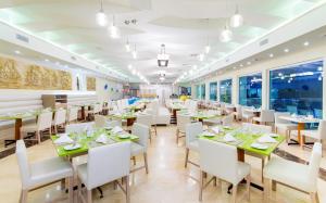 卡塔赫纳卡塔赫纳大恩酒店的一间设有白色桌子和白色椅子的餐厅