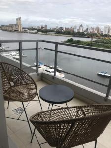圣达菲Puerto Apart的俯瞰水面的阳台配有两把椅子和一张桌子