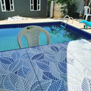 马卡埃Cantinho do sossego的游泳池配有桌子和两把椅子