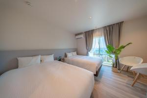 宫古岛Crystal Villa ikema的酒店客房设有两张床和一张桌子。