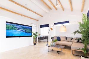 宫古岛Crystal Villa ikema的客厅配有沙发和墙上的电视