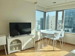 首尔Hongik univ station Exit 1的客厅配有电视和桌椅