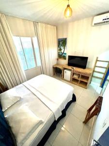 费尔南多 - 迪诺罗尼亚Coral azul Noronha的一间卧室配有一张床和一台平面电视