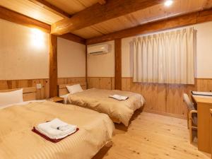 高知Tennenonsen Harunonoyu的客房设有两张床、一张书桌和一张书桌