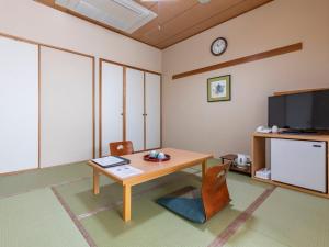 高知Tennenonsen Harunonoyu的客厅配有桌子和电视