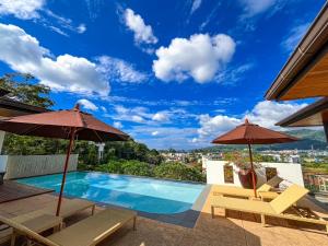 卡马拉海滩Villa Tantawan Resort - Private Pool Villas的一个带两把遮阳伞的景观游泳池