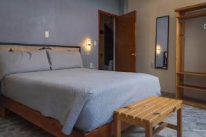 瓜纳华托Hotel Corazón de Plata Centro的一间卧室配有一张大床和一张木桌