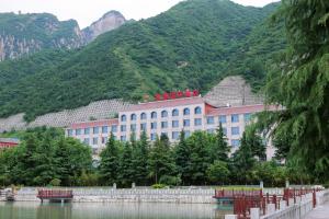 华阴华山欣源国际酒店的一座在山顶上的人居住的建筑,毗邻一座山