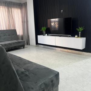卡塔赫纳Apartamentos San José的客厅配有白色橱柜上的平面电视