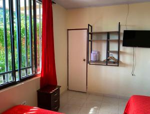 金巴亚Hotel Casa campestre HH的卧室设有门和红色窗帘