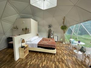 曼努埃尔安东尼奥La Comarca River Glamping Dome near Manuel Antonio的圆顶帐篷内的卧室配有1张床和1张桌子