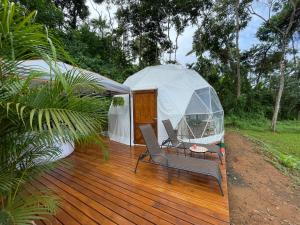 曼努埃尔安东尼奥La Comarca River Glamping Dome near Manuel Antonio的木制甲板上配有桌椅的凉亭